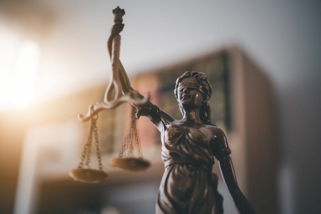 Bronze statue of Lady Justice holding balanced scales, blindfolded to symbolize impartiality in law.